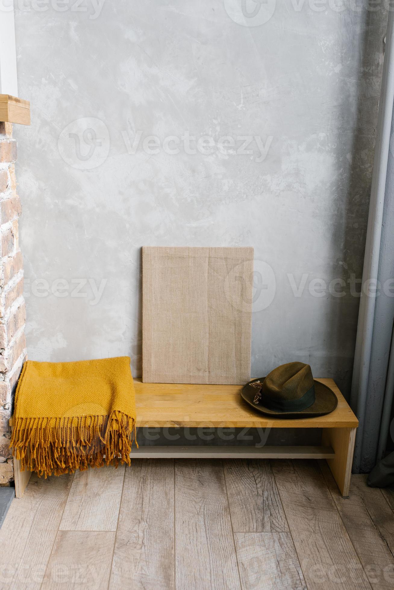 xadrez marrom, chapéu de feltro e tela em um banco de madeira no